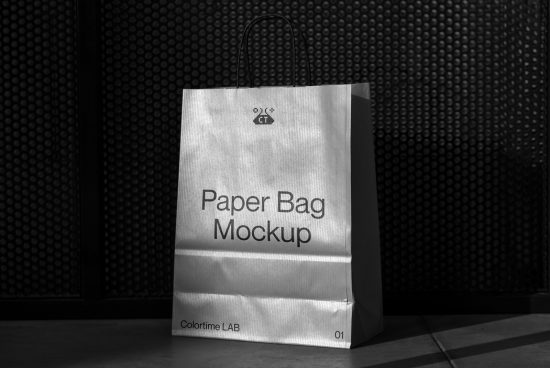 High-contrast black and white paper bag mockup on floor against dotted backdrop, ideal for packaging design presentation.